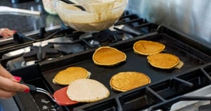 Flipping pancakes on a griddle in the kitchen