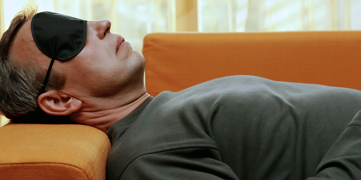 a man wearing an eye mask and ear plugs while engaging in Ketamine Assisted Therapy