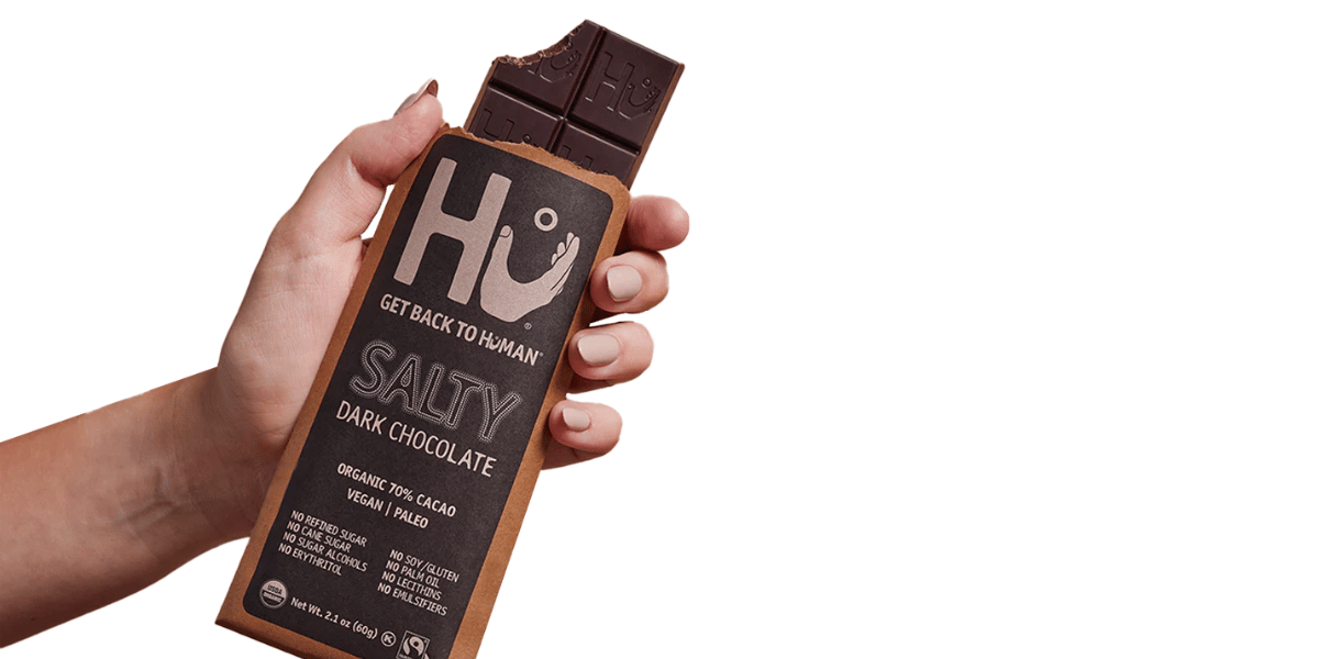 hand holding out Hu dark chocolate bar