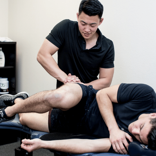 JUSTIN CHENG, DC Chiropractor/Soft-Tissue Therapist working on a student
