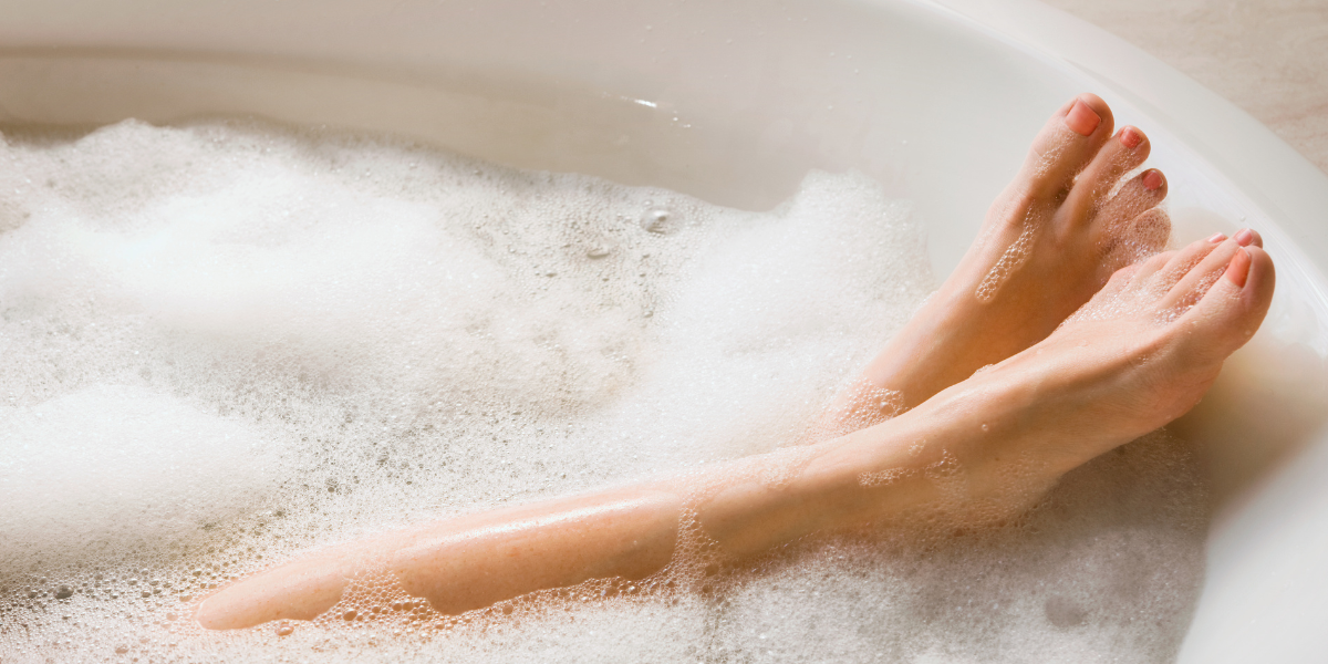 Suds covered feet in a bath tub