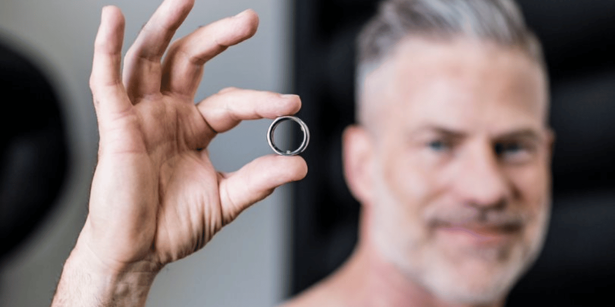a man holds up an Oura Ring