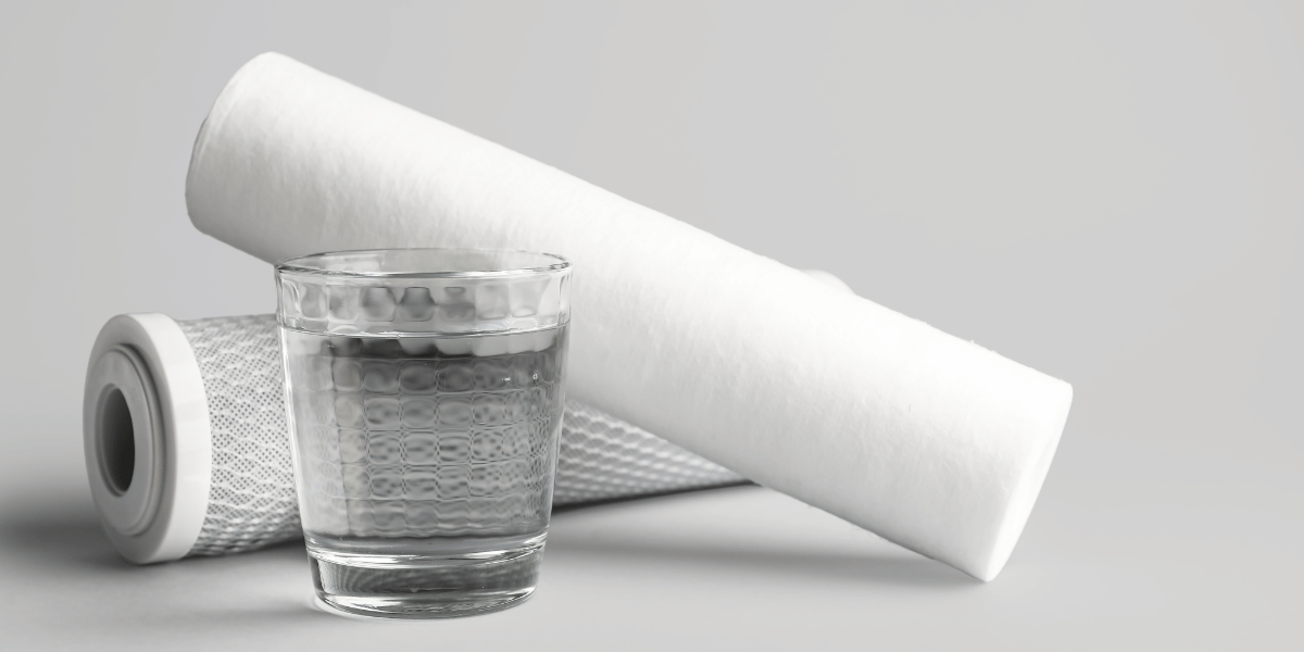 a glass of water in front of multiple water filters
